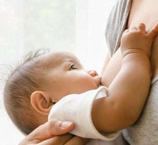 Baby breastfeeding in soft natural light.