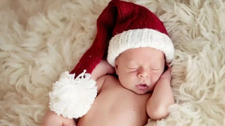 Red and white knit santa hat with pom-pom, soft material suitable for newborns.